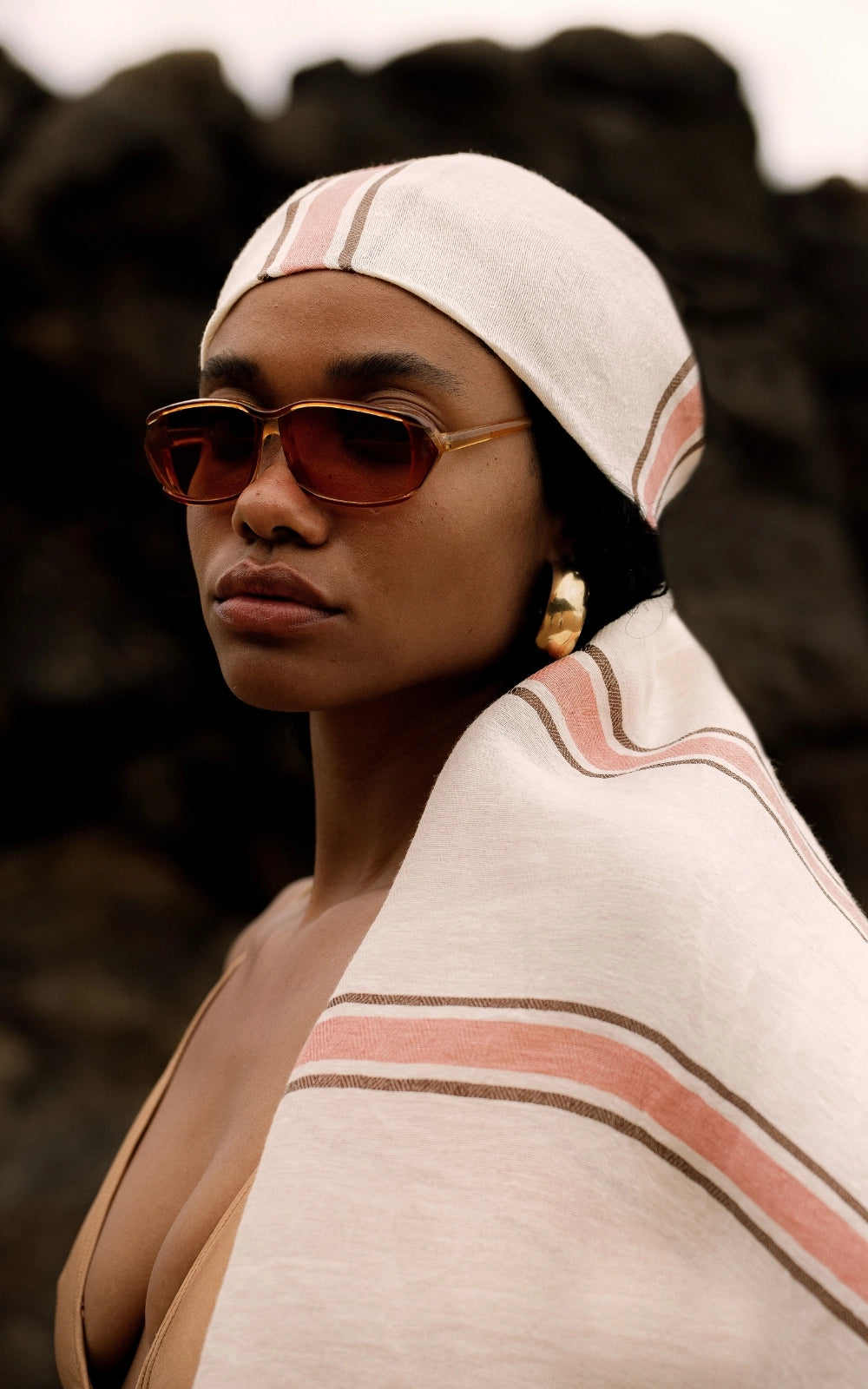 Woman with sunglasses wearing a linen fouta around her hair 