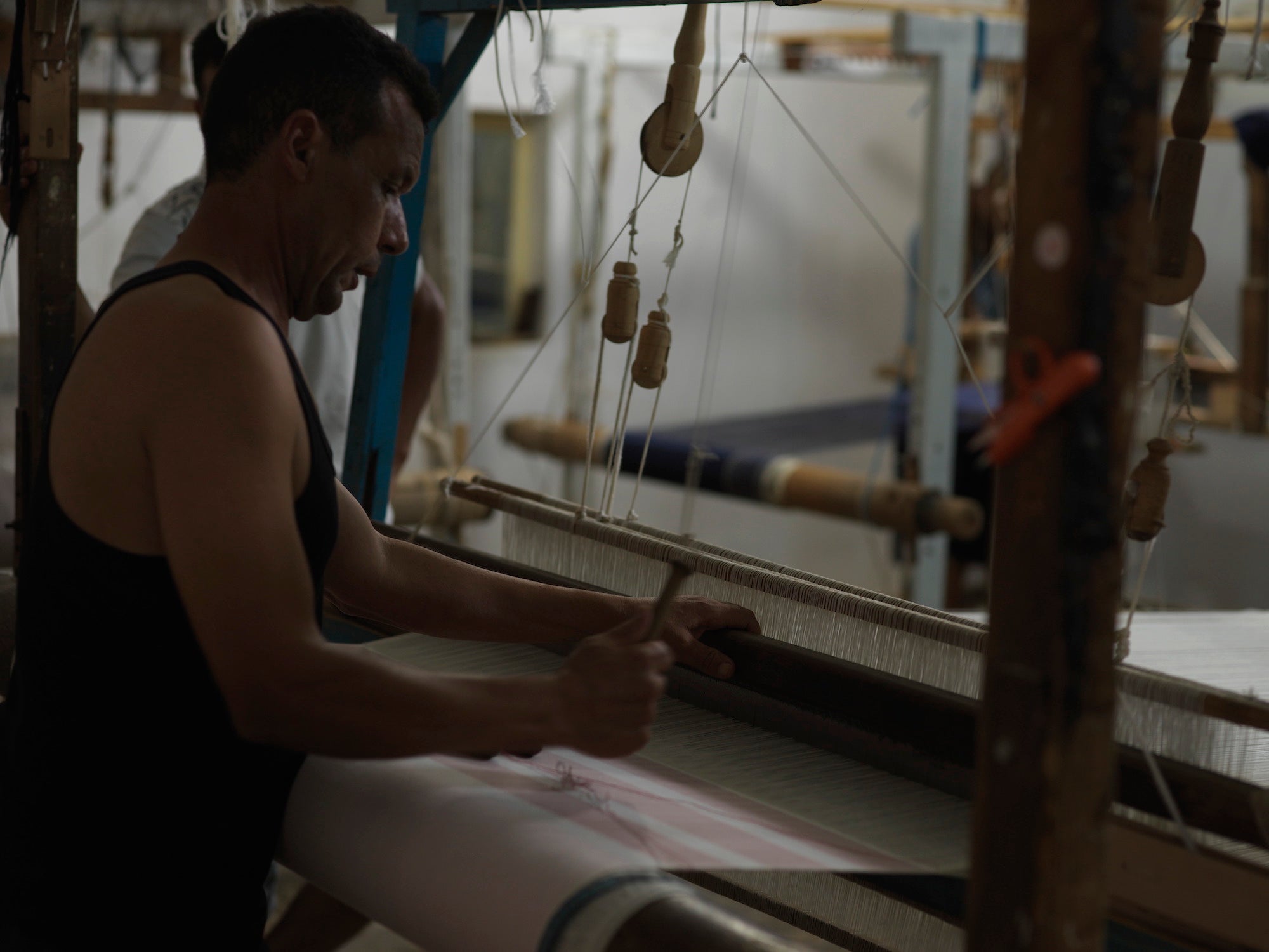 Weaver on pedal loom at Nsija Atelier in Mahdia